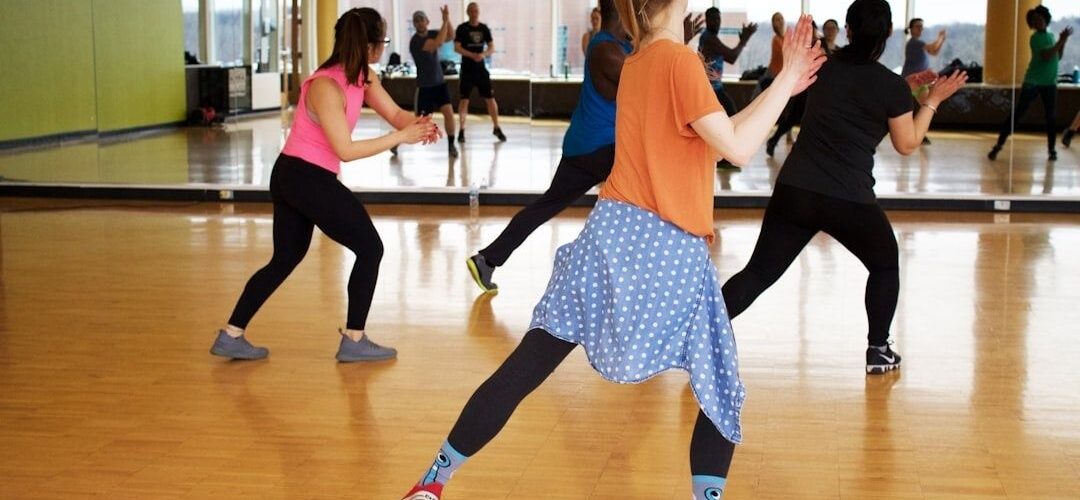 Dansehold øver koordinerede trin i et spejlet træningslokale