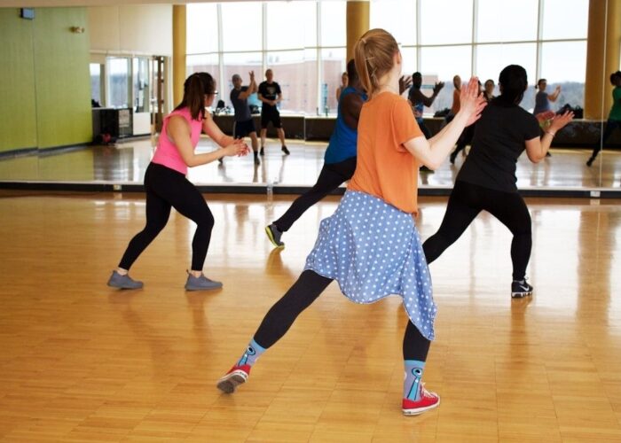 Dansehold øver koordinerede trin i et spejlet træningslokale