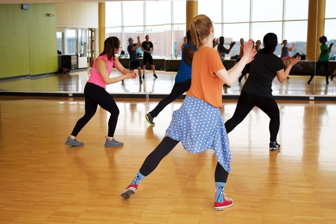Dansehold øver koordinerede trin i et spejlet træningslokale